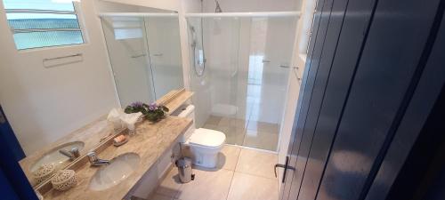 a bathroom with a shower and a sink and a toilet at Quinta dos Faisões in Santo Antônio do Pinhal