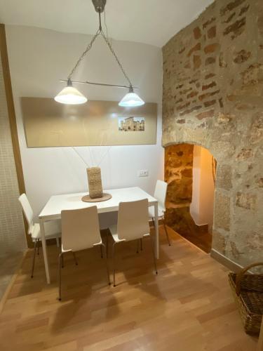 a dining room with a white table and chairs at Apartamentos Caceres in Cáceres