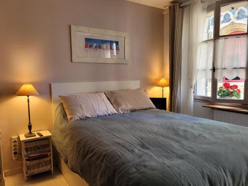 une chambre avec un lit et deux lampes et une fenêtre dans l'établissement Charmant gîte au rez-de-chaussée avec cour fleurie, centre historique du Croisic, plage à 900m - FR-1-306-916, au Croisic