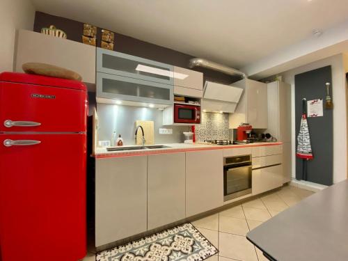 Cette chambre comprend une cuisine équipée d'un réfrigérateur rouge. dans l'établissement Charmant gîte au rez-de-chaussée avec cour fleurie, centre historique du Croisic, plage à 900m - FR-1-306-916, au Croisic