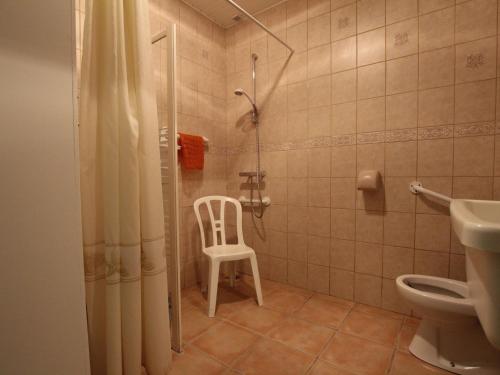 y baño con ducha y silla blanca. en Gîte Bouin, 4 pièces, 9 personnes - FR-1-426-95, en Bouin