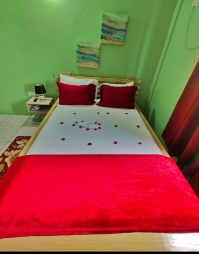 a bedroom with a large bed with a red blanket at Isla Vista Apartment Canouan #2 in Canouan