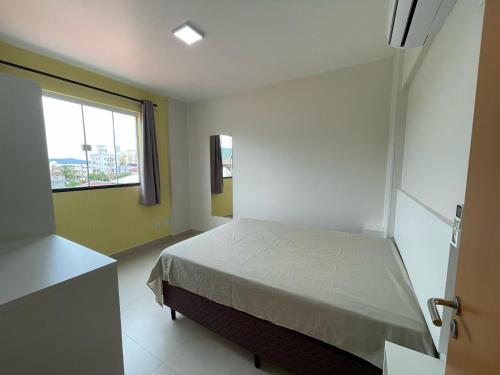 a bedroom with a bed and a window at Residencial Helena in Porto Belo