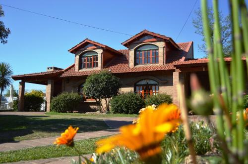 a house with a garden in front of it at Cabañas La Aldea in Villa Carlos Paz