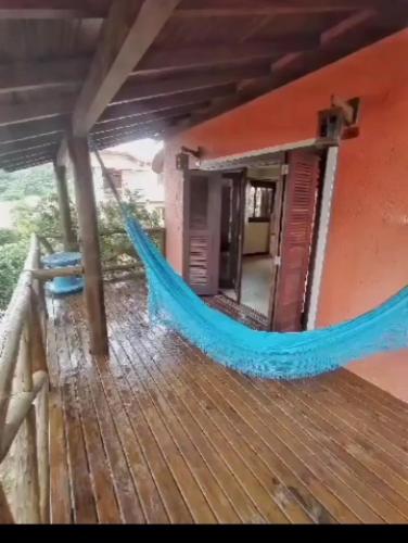 a hammock on a porch of a house at Vista da lagoa Ferrugem garopaba in Garopaba