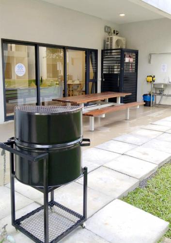 a grill in a room with a table and benches at Roxy Sematan Beach Townhouse Deluxe 7 ,8 ,9, 10 ,11 ,12 in Sematan