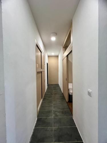 a hallway with white walls and tile floors at Roxy Sematan Beach Townhouse Deluxe 7 ,8 ,9, 10 ,11 ,12 in Sematan