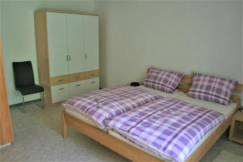 um quarto com uma cama com uma cómoda e uma cadeira em Haus am Waldrand em Triberg