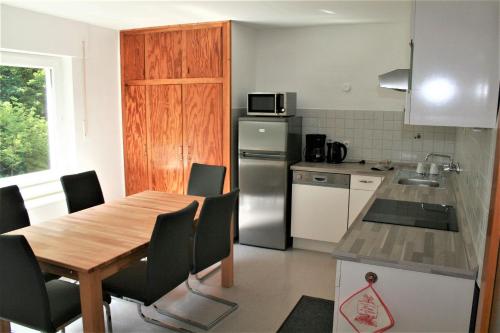 Haus am Waldrand في تيبرغ: مطبخ مع طاولة وكراسي وثلاجة