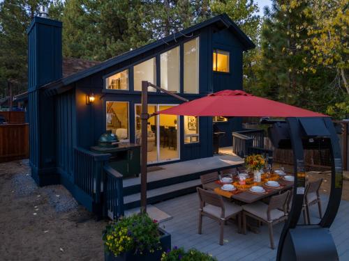 a blue tiny house with a table and an umbrella at Waves End Lakefront - 3BR Tahoe Vista w Private Sandy Beach, Walk to Town! in Tahoe Vista