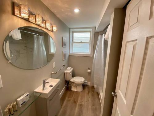 een badkamer met een wastafel, een toilet en een spiegel bij Hidden Getaway, BSMT with Back Yard in Halifax