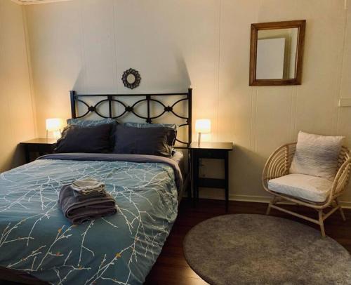 una camera con letto, sedia e orologio di Cozy 2-BDRM, Mid Floor, Backyard a Halifax