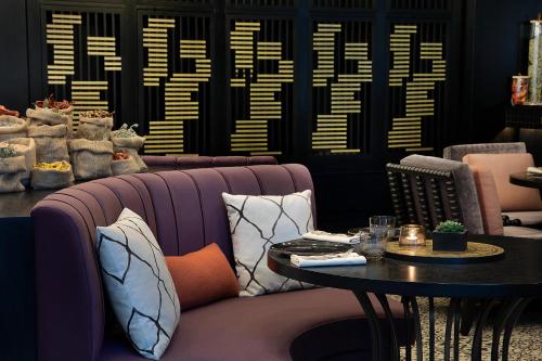 a restaurant with a purple couch and a table at The St. Regis Amman in Amman