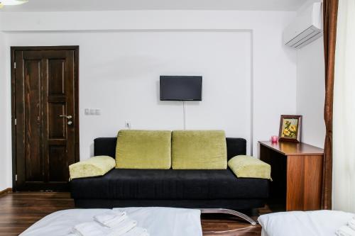 a black couch with two green pillows in a room at Бялата къща in Zlatograd