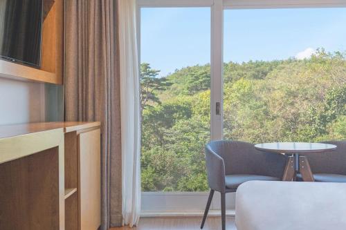 een kamer met een groot raam met een tafel en stoelen bij EL Hotel in Yangyang