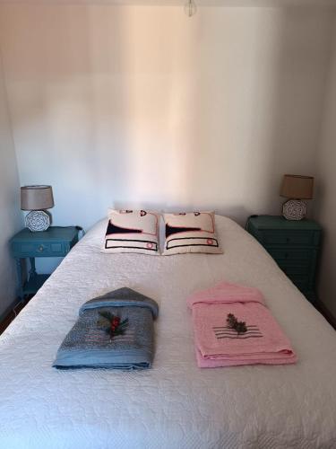 a bed with pink towels on it with two lamps at Cantinho d'Alice in Valezim