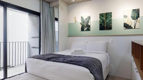 a bedroom with a bed and a large window at Charlie Porto Alegre Praça 4 in Porto Alegre