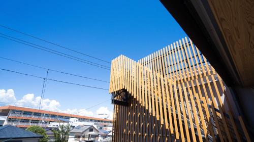 a tall wooden building with a blue sky in the background at Hotel Re:Plug in Kochi