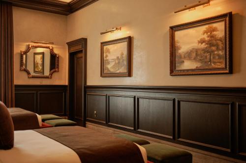 a hotel room with two beds and paintings on the wall at Todos Santos Boutique Hotel in Todos Santos