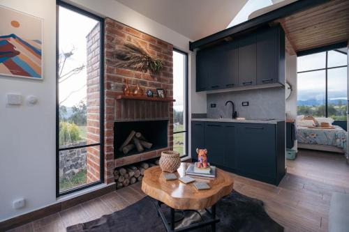 a kitchen and living room with a brick fireplace at Casa con vista a las montañas in Quito