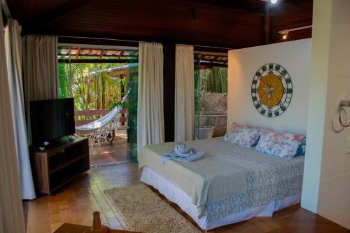 a bedroom with a bed and a tv in a room at Pousada Casa de Charme in Lençóis