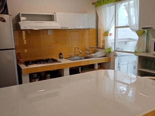 a small kitchen with a sink and a refrigerator at Bonita casa de descanso en Cuautla Morelos in Tlayecac