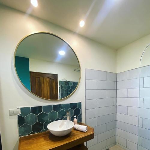 a bathroom with a sink and a mirror at Oasis by Franklin Hotel Boutique in Fortuna