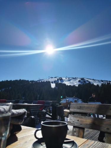 a cup on a table with a view of a mountain at President Kop Apartman 106 in Kopaonik