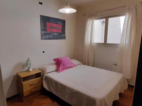um pequeno quarto com uma cama e uma janela em Emilio Civit em Mendoza
