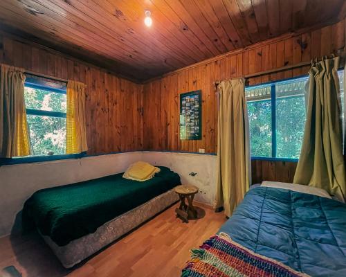 カブルグアにあるCasa con acceso directo al lago.の木製の壁のベッドルーム1室(ベッド2台付)