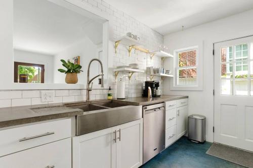 uma cozinha com armários brancos e um lavatório em The Oyster House Downtown em Charleston