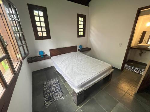 Un pat sau paturi într-o cameră la Camburi Chalés