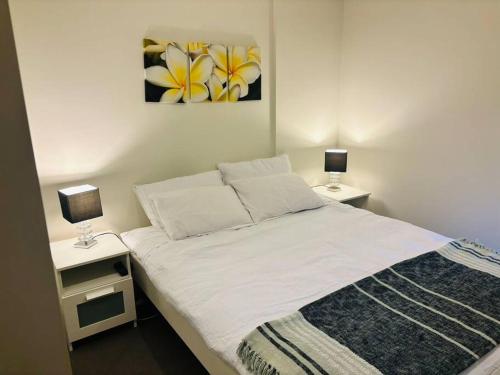 een slaapkamer met een bed met 2 nachtkastjes en 2 lampen bij Modern 1 Bdr APT in South Yarra (TF50424) in Melbourne