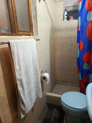 baño con aseo y toalla blanca en Centric Room, en Riobamba