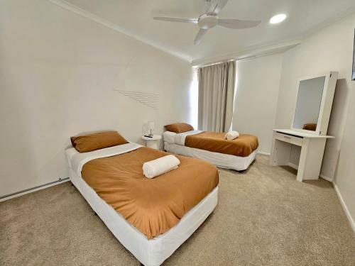 a bedroom with two beds and a ceiling fan at Deluxe Two Bedroom Apartment with Ocean Views in Coolum Beach