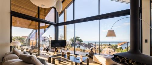 d'un salon avec de grandes fenêtres et une vue sur l'océan. dans l'établissement SEAVIEW KEYWEEK Villa pool sea view Anglet, à Anglet