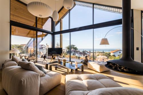 - un salon avec de grandes fenêtres et un grand canapé dans l'établissement SEAVIEW KEYWEEK Villa pool sea view Anglet, à Anglet