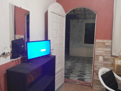 um quarto com uma televisão numa cómoda com um espelho em Meu Quarto no Rio de Janeiro em Duque de Caxias