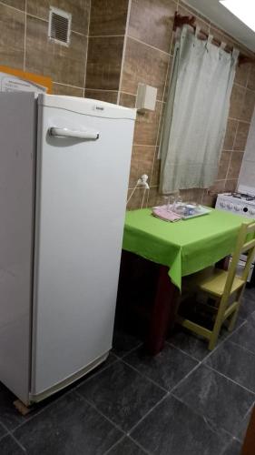 La cuisine est équipée d'une table verte et d'un réfrigérateur. dans l'établissement apartamento los lobos, à Mar del Plata