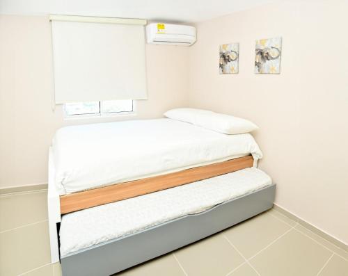 a bedroom with two beds and a window at Excelente ubicación y cómodo apto, perfecto para ti! in Barranquilla