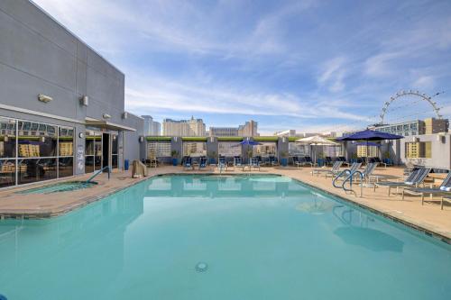 a large swimming pool with chairs and a ferris wheel at Princess Suite Platinum Hotel in Las Vegas