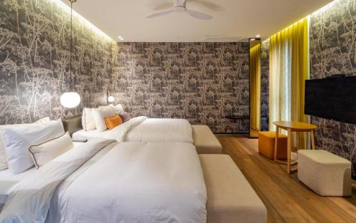 a bedroom with two white beds and a tv at Hotel Barahan Jeonju in Jeonju