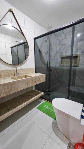 a bathroom with a sink and a toilet and a mirror at Arembepe - Aldeia St Sebastien Casa Mar 10 in Camaçari