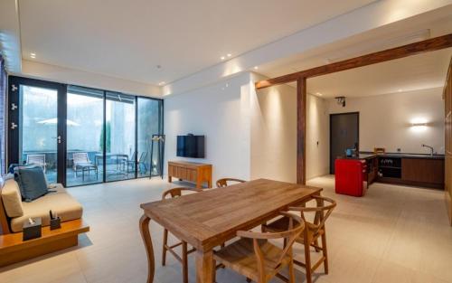 a living room with a wooden table and chairs at Hotel Barahan Jeonju in Jeonju