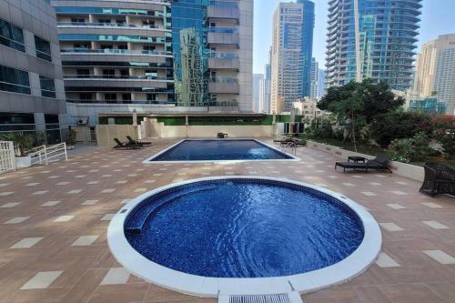a large swimming pool on the roof of a building at Full Marina View 2BR Luxury Apartment in Dubai
