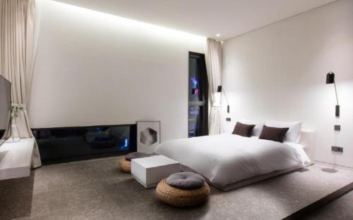 a bedroom with a white bed and a fireplace at Hotel Barahan Jeonju in Jeonju