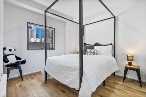 Un dormitorio con una cama grande y un oso panda en una silla en Central City Chic - sleeps 6, free parking en Melbourne