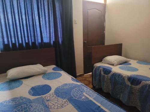 - 2 lits dans une chambre avec des draps bleus et blancs dans l'établissement HOTEL K'RITAS K'STRO, à Ica