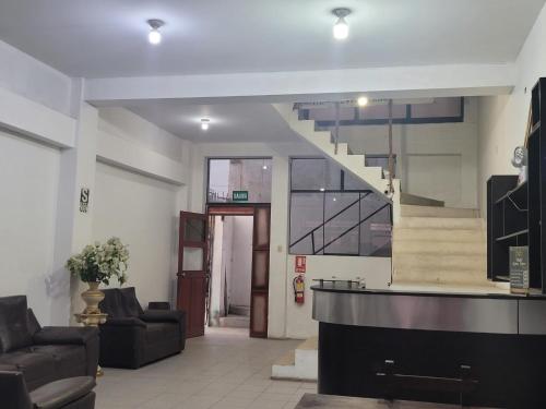 un hall avec un escalier dans un bâtiment dans l'établissement HOTEL K'RITAS K'STRO, à Ica