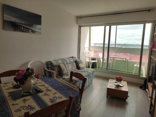 un salon avec un canapé et une table dans l'établissement Appartement en front de mer avec garage, WIFI et grand balcon - Saint-Hilaire-de-Riez - FR-1-652-31, à Saint-Hilaire-de-Riez